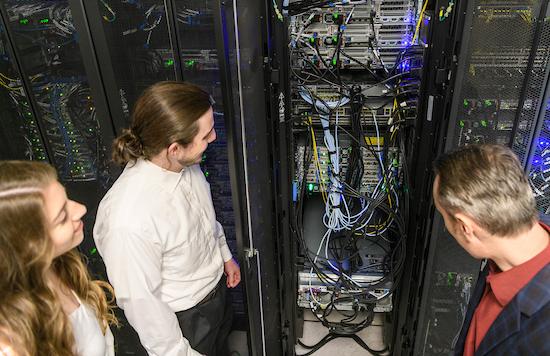 people look at large cabinet of electronic hardware